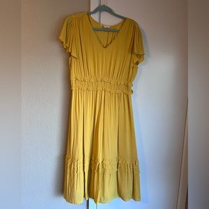 Yellow knee length dress with ruffle details.